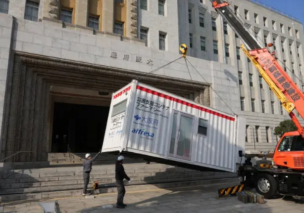 写真：コンテナファーマシーをクレーンで吊り下げている