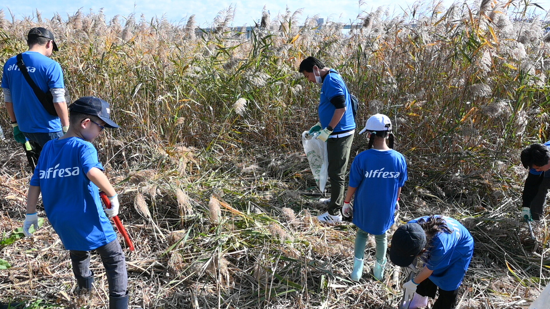 ゴミ拾いをする社員と家族